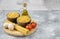 Bowls of raw pasta, eggs, tomatoes and olive oil on marble surface