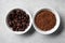 Bowls with roasted beans and instant coffee on light grey table, flat lay