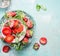 Bowls with sliced Strawberries with powdered sugar and mint leaves on light blue rustic background