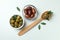 Bowls and spoon of olives, and leaves on white background