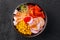 Bowls with tasty rice, shrimps and vegetables on dark background