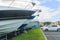 The bows of boats sticking out of the rack for storing stand in front of cars