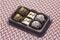 Box with assortment of bonbons, chocolate and coconut, white chocalate and chocolate with chestnut.