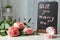 Box with beautiful engagement ring and roses on light table