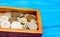 box with coins of countries of the world on a blue wooden background. money. a Palestinian, a Soviet, an Israeli, a Ukrainian coin