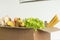 Box filled with food on an isolated background. In the box are vegetables, fruits, bananas, carrots, eggs, fresh salad, spaghetti