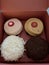 Box of four cupcakes coconut chocolate strawberry caramel