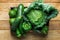 Box with Fresh Organic Green Vegetables Savoy Cabbage Zucchini Cucumbers Bell Peppers Avocados on Aged Plank Wood Background