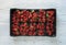 Box of fresh ripe perfect strawberries on white rustic wooden background.