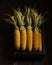 Box full of fresh corn cobs on the dark rough wood