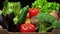 A box full of fresh vegetables on a dark background, wooden vintage table. In zoom motion.