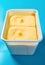 Box of mango flavor ice cream on blue background vertical composition