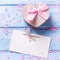 Box with present in form of heart, petals of sakura pink flowers