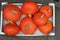 A box with seven orange pumpkins closeup