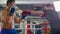 Box training indoors - two men having an aggressive fight on the boxing ring - one of the men wearing a black t-shirt