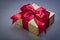 Boxed gift in glittery paper on grey background holidays concept