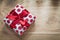 Boxed present with red ribbon on wooden board holidays concept