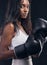 Boxer champion, woman and portrait on black background for sports, strong focus or mma training. Female boxing, gloves