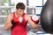 Boxer doing some training on punching bag at gym.