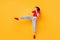Boxer girl practicing air kicks raise leg jumping high wear red crop top jeans isolated yellow color background