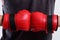 Boxer presses hands together. Man wears red boxing gloves.