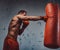 Boxer with protective gloves hitting a punching bag