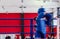 Boxer in the ring. Boxer in full gear. Children`s sports. Thai boxing. Boxing competition.