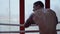 Boxer with tattoos stands in the ring with his back to the camera
