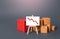 Boxes and container near the easel with a red down arrow. Drop of goods transportation volume, world trade traffic reduction