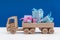 Boxes with gifts in blue with white polka dots and pink paper, lucky toy wooden truck. Holiday concept.