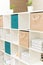 Boxes and organizers in a white office cabinet. Bright office in blue and beige tones