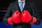 Boxing businessman with red gloves in box ring