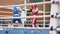 Boxing competitions among young men. Silhouettes of athletes in boxing ring. Boxers in helmets and mitts leading the