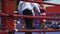 Boxing match in the ring. Two participants competing with each other. The referee watching the fight. Red-blue ring