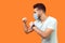 Boxing and self-defence. Side view of aggressive man with surgical medical mask keeping fists clenched, ready for fight. empty