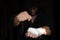 Boxing taping. Male hands of pro fighter with bandage on the fists, low key, selected focus.