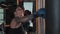 Boxing - a tattooed woman punching the punching bag with an effort