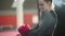 Boxing training - an attractive young woman puts on red boxer gloves