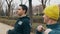 Boxing workout with trainer outdoors. The coach with yellow knit cap explains stretching movements to young caucasian