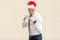 Boxing. Young adult ginger businessman on red santa hat, ready for fight on light orange background.