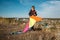 A boy of 10 years old is holding a kite. Bright sunny day. In the background is a small town