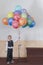 Boy 4 years holding colorful balloons. Happy boy on the stage holding balloons