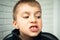 A boy of 6-7 years old shows the first teeth that grow after the loss of milk teeth. Closeup of a boy's face