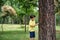 Boy 7-9 years old white Caucasian looks attentively at the tree while standing in the forest near a beech tree in early summer or