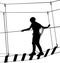 Boy in adventure park rope ladder. Silhouette Adventure. Extreme sportsman took down with rope. Sport weekend action in adventure