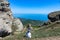 A boy against the background of ancient limestone high mountains. The Valley of Ghosts. Demerji. Crimea.