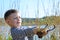 Boy Aiming Sling Shot Outdoors by Lake