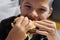 Boy with appetite eats delicious hamburger. child bites off large piece of sandwich