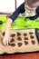 Boy arranges cut out cookie shapes on a baking tray. In the background, silicone coffee table and cookie cuttersB