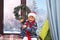 Boy asleep on Christmas night . Boy in Santa hat sleeping on the windowsill